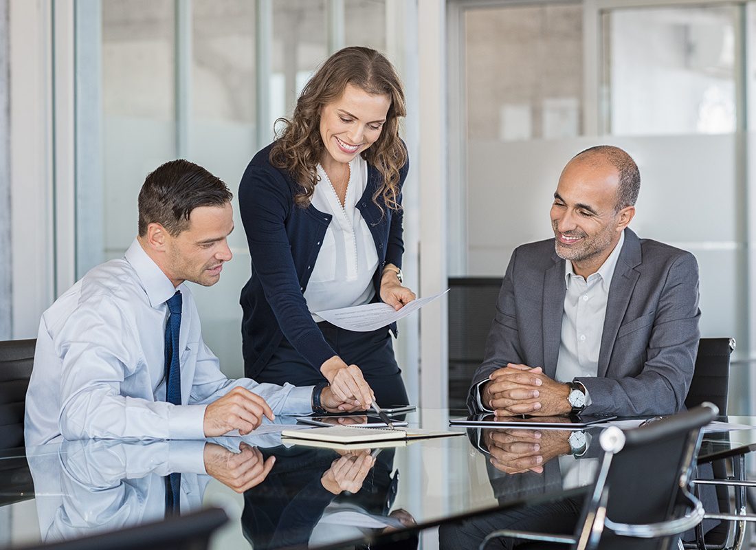 Insurance Solutions - Group of Business Professionals Review Documents During a Meeting at an Office